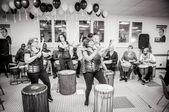 Groupe de musiciens jouant des percussions lors d'un événement festif.